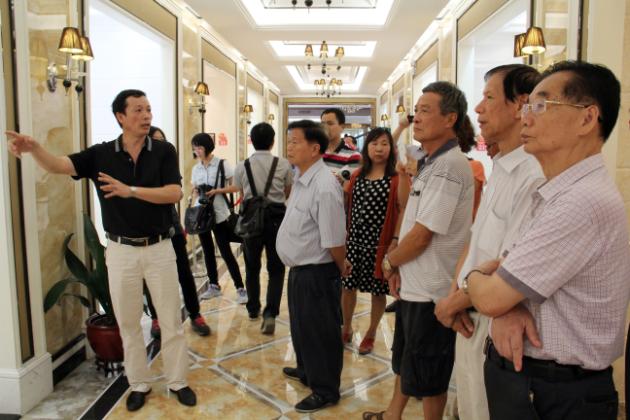 图3、91免费版视频市场总监霍达炎（左一）在为参观者介绍釉面砖展示空间.jpg